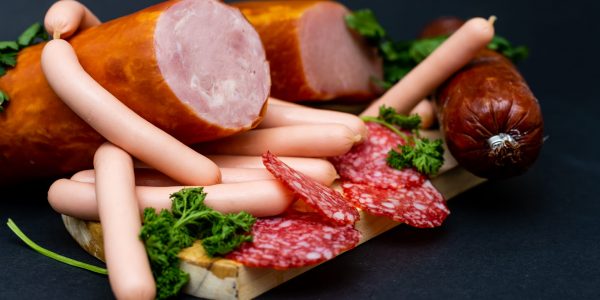 composition of cold cuts on wooden board with different type of cheese